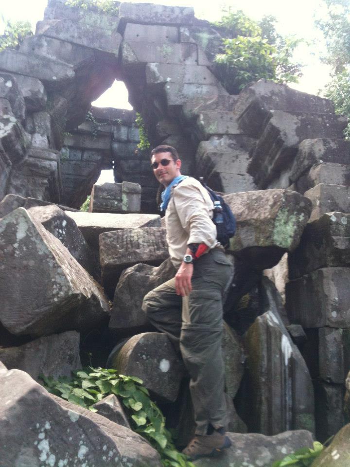 Jay Rice climbing a ruin in Cambodia.