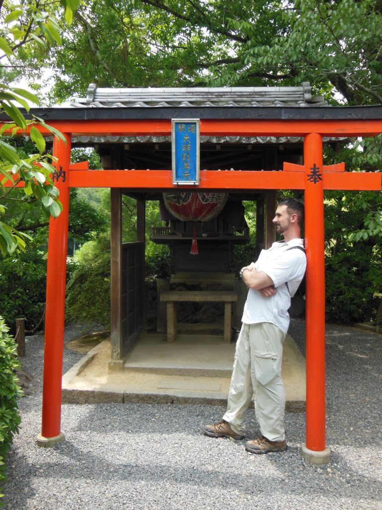 Jay Rice leaning against a temple gate in Japan.